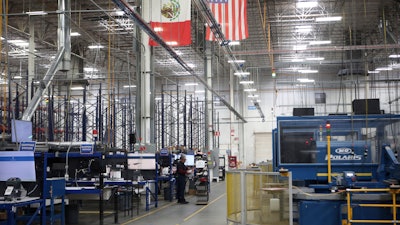 National flags representing the United States and Mexico hang inside in a textile factory that produces T-shirts, in Ciudad Juarez, Mexico, Tuesday, Feb. 4, 2025.