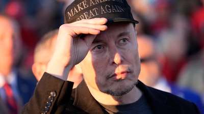 Elon Musk listens as Republican presidential nominee former President Donald Trump speaks at a campaign event at the Butler Farm Show on Oct. 5, 2024, in Butler, Pa.