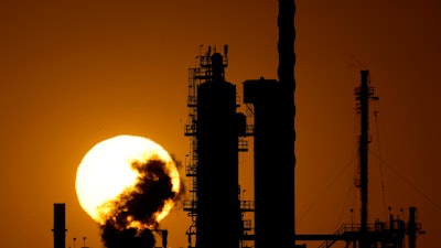 The CHS oil refinery is silhouetted against the setting sun Sept. 28, 2024, in McPherson, Kan.