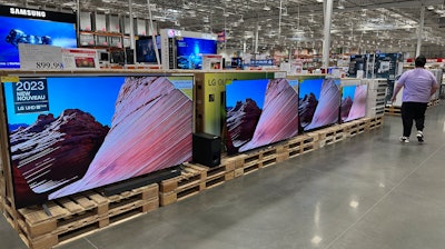 A shopper passes by a display of large-screen televisions in a Costco warehouse Monday, Feb. 3, 2025, in east Denver.