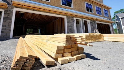 Lumber is piled at a housing construction site, June 24, 2021, Middleton, Mass.