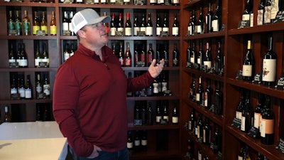 Craig Ledbetter of Vino Farms looks at locally made wines at the Lodi Wine Visitor Center, Lodi, Calif., March 18, 2025.