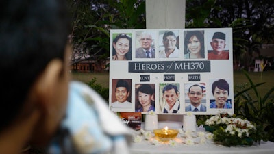 A Malaysian boy wipes his tears during a special prayer for the ill fated Malaysia Airlines Flight 370 at a church in Kuala Lumpur, Malaysia, Tuesday, March 8, 2016.