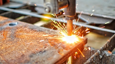 A machine cutting through thick steel with high temperature application.