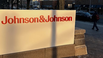 A person walks by the Johnson & Johnson headquarters is in New Brunswick, N.J., on Thursday, Feb. 8, 2024.