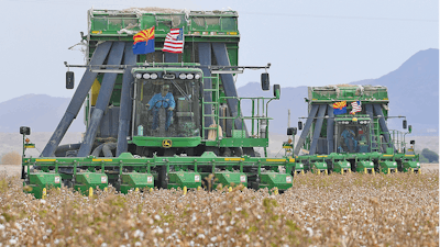 Two John Deere on board module cotton strippers, owned and operated by DVB Harvesting, work their way through a field of cotton on Aug. 21, 2020, in Winterhaven, Ariz.