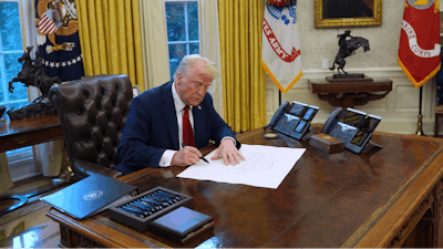 President Donald Trump signs executive orders in the Oval Office at the White House, Thursday, Jan. 30, 2025, in Washington.